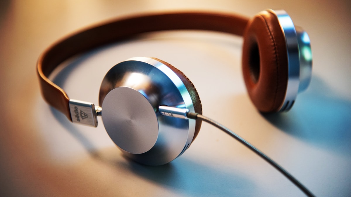 Headphones resting on a smartphone showing a music app