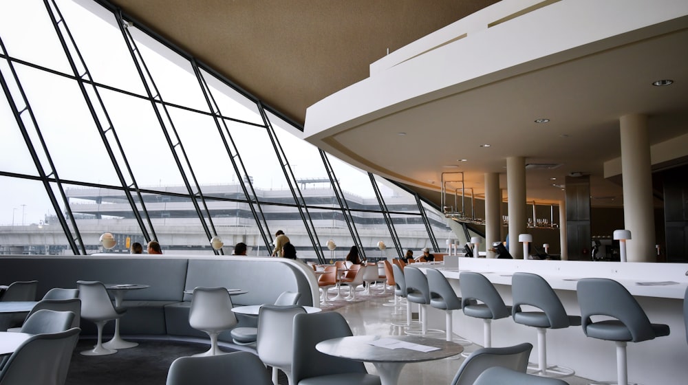 A domestic airport lounge with seating and floor-to-ceiling windows